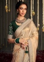 Shimmer Net Gold-coloured saree featuring an all-over heavy gold zari butta and sequence work on body decorated with border with contrast navy blue piping - Image 3